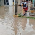Inundación deja sin clases a 75% de alumnos de kínder Bicentenario de la Independencia en Altamira; niños entran por acceso trasero. 